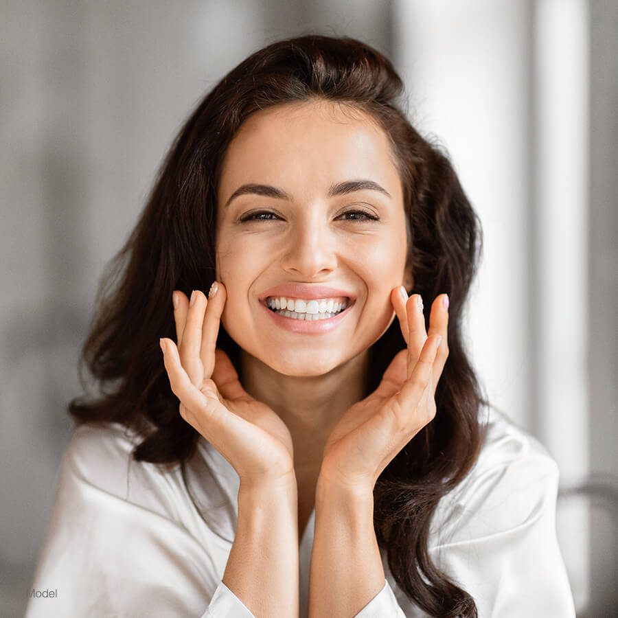 Smiling woman with both hands on her cheeks